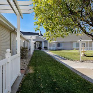 A peaceful pathway leading through a well-maintained residential area with lush green lawns.