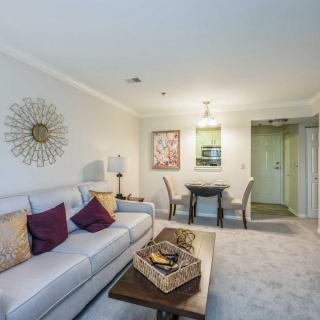 A modern living room with a comfortable sofa, stylish decor, and a cozy dining area.
