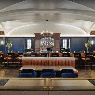 Elegant restaurant interior featuring a central bar and stylish seating.