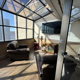 A bright and inviting sunroom featuring comfortable seating and large windows, perfect for relaxation.