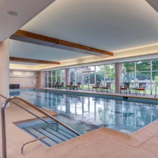 A spacious indoor swimming pool area with natural light and comfortable seating.