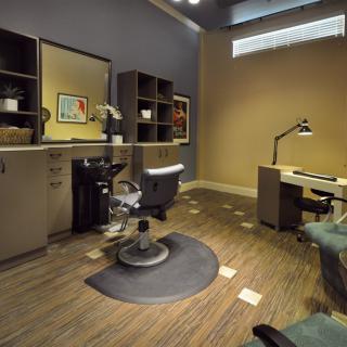 A modern salon interior with a styling chair and workspace setup.