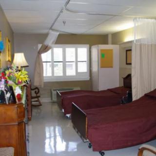 A hospital room with two beds separated by curtains.
