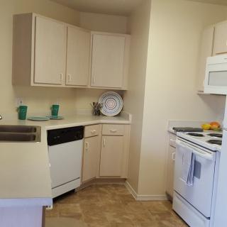 A compact kitchen with beige cabinets and modern appliances.