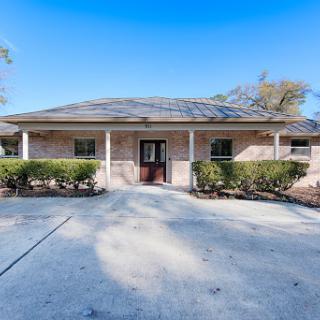 A charming single-story house featuring a welcoming porch and well-maintained landscaping.