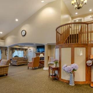 A spacious and cozy living room with elegant decor, featuring a loft area and warm lighting.