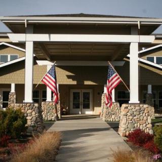 A building entrance with two American flags and decorative stone columns.