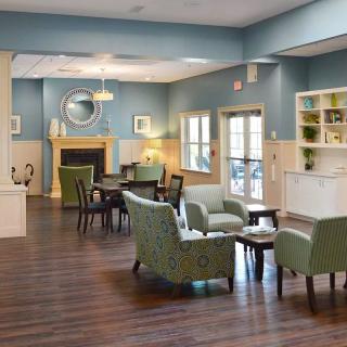 A modern living room with comfortable seating, a fireplace, and stylish blue walls.