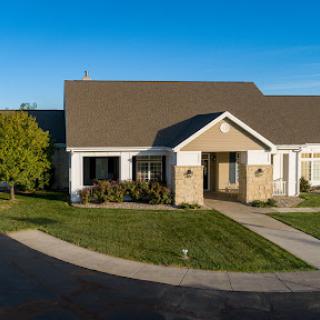 A charming residential house with well-maintained landscaping under a clear blue sky.