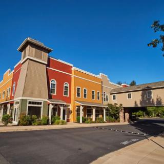 A vibrant commercial building complex under a clear blue sky.