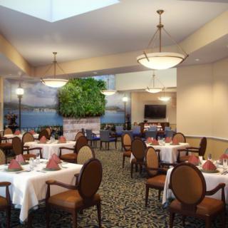 A well-lit dining area with neatly arranged tables and chairs.
