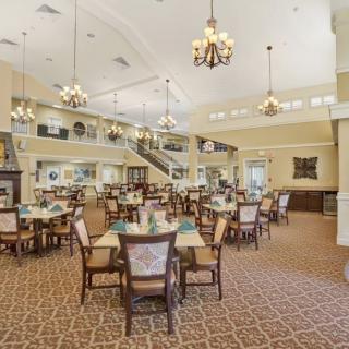 An elegant dining room with multiple tables and chandeliers.