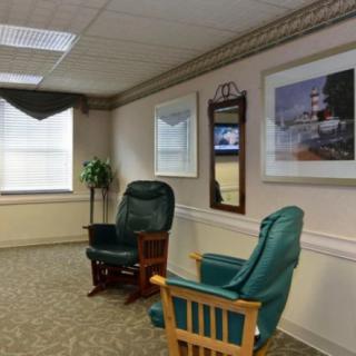 A cozy waiting room with comfortable chairs and decorative artwork on the walls.