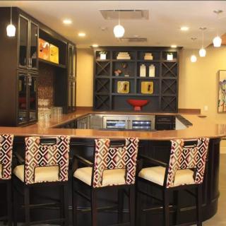 A modern kitchen bar area with patterned stools and stylish shelving.