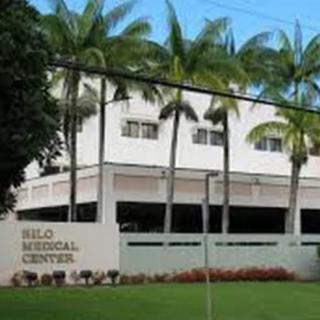 The exterior of Hilo Medical Center with palm trees lining the front.