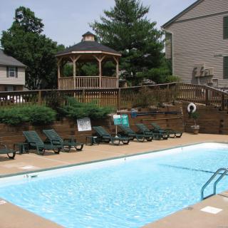 Outdoor swimming pool area with lounge chairs and a gazebo nearby.