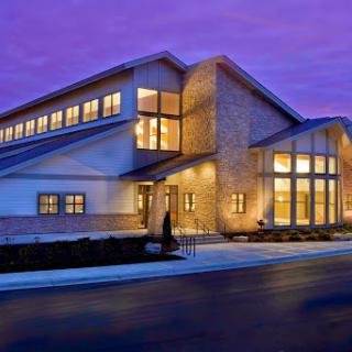 A modern architectural building illuminated at dusk.