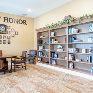 A cozy interior with bookshelves, a seating area, and a wall of honor.