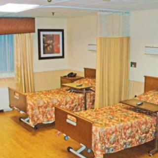 A hospital room with two beds separated by curtains.