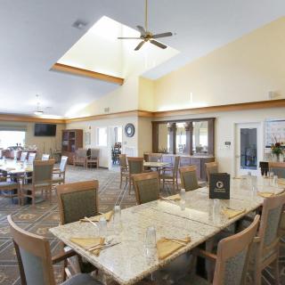A spacious and well-lit dining room with several tables and chairs arranged neatly.