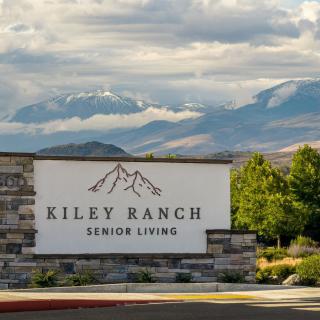 Entrance sign for Kiley Ranch Senior Living with mountainous landscape in the background.