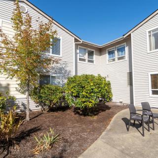 A well-maintained residential building with a small outdoor seating area on a sunny day.