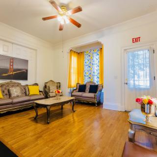 A cozy living room with stylish furniture, hardwood flooring, and a ceiling fan.