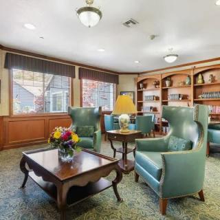 A cozy living room with armchairs and bookshelves.