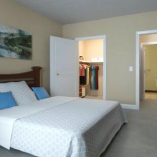 A cozy bedroom with a neatly made bed and open closet.
