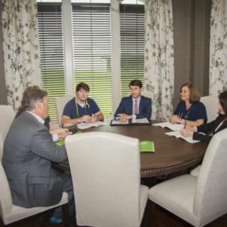 A group of individuals having a business meeting around a round table.