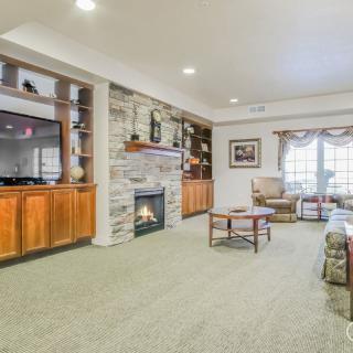 A cozy living room with a stone fireplace, television, and comfortable seating.