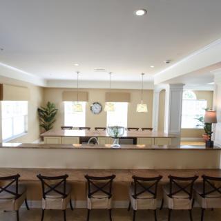 A modern kitchen interior with a long counter and stools.