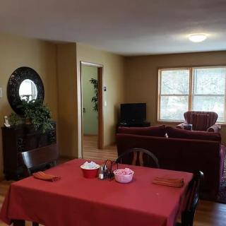 A cozy living and dining area with a table set for a meal, comfortable seating, and a TV.