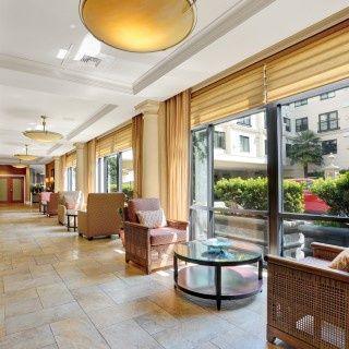 A bright and spacious hotel lobby with comfortable seating and large windows letting in natural light.