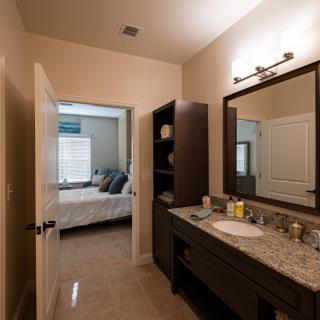 A view from the bathroom into the bedroom, featuring a sink and a mirror.