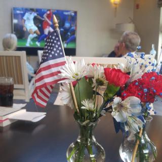 Enjoying a soccer game while celebrating with flowers and the American flag.