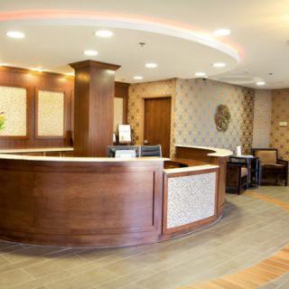 A modern reception area with a wooden desk and comfortable seating in the lobby.