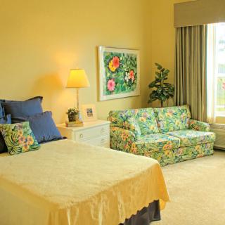 A cozy bedroom with floral decor and warm lighting.
