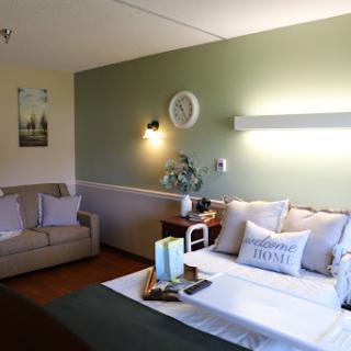 A cozy and elegantly styled bedroom featuring a green accent wall and inviting furnishings.
