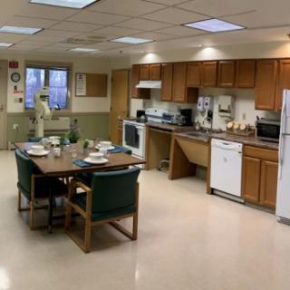 A spacious kitchen and dining area with appliances, cabinets, and a set dining table.