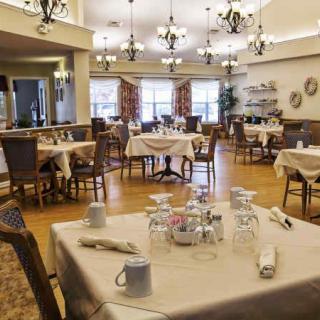 A spacious and elegantly decorated dining area with empty tables set for guests.