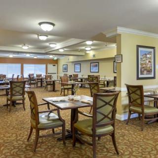 An empty dining room with neatly arranged tables and chairs.
