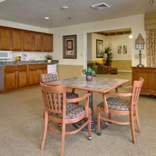 A cozy dining area with wooden furniture and a kitchenette.