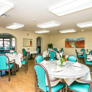 An elegant dining room with neatly arranged tables and chairs, featuring contemporary decor.