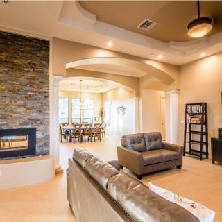A modern living room featuring a cozy fireplace, elegant furniture, and stylish ceiling lights.