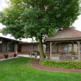 A serene outdoor space featuring a charming gazebo, lush greenery, and beautifully landscaped gardens.