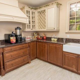 A cozy kitchen with wooden cabinets, a farmhouse sink, and modern appliances.