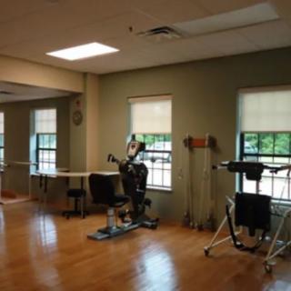 A rehabilitation room featuring exercise equipment and therapy tools.