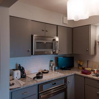 A modern kitchen featuring essential appliances and a cozy arrangement.