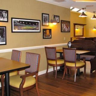 A cozy restaurant dining area with neatly arranged tables and chairs, adorned with framed artwork on the walls.